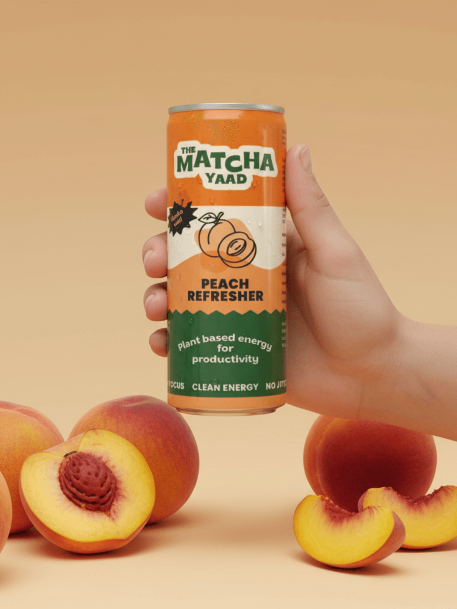 Hand holding Peach Refresher matcha energy drink can with fresh peaches around, showcasing a natural, uplifting beverage for clean energy.