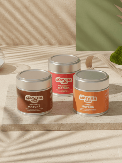 Flavoured Matcha Trio with Chocolate, Strawberry, and Peach Matcha tins displayed on a sunlit surface. Ideal for iced drinks and energy boosts.