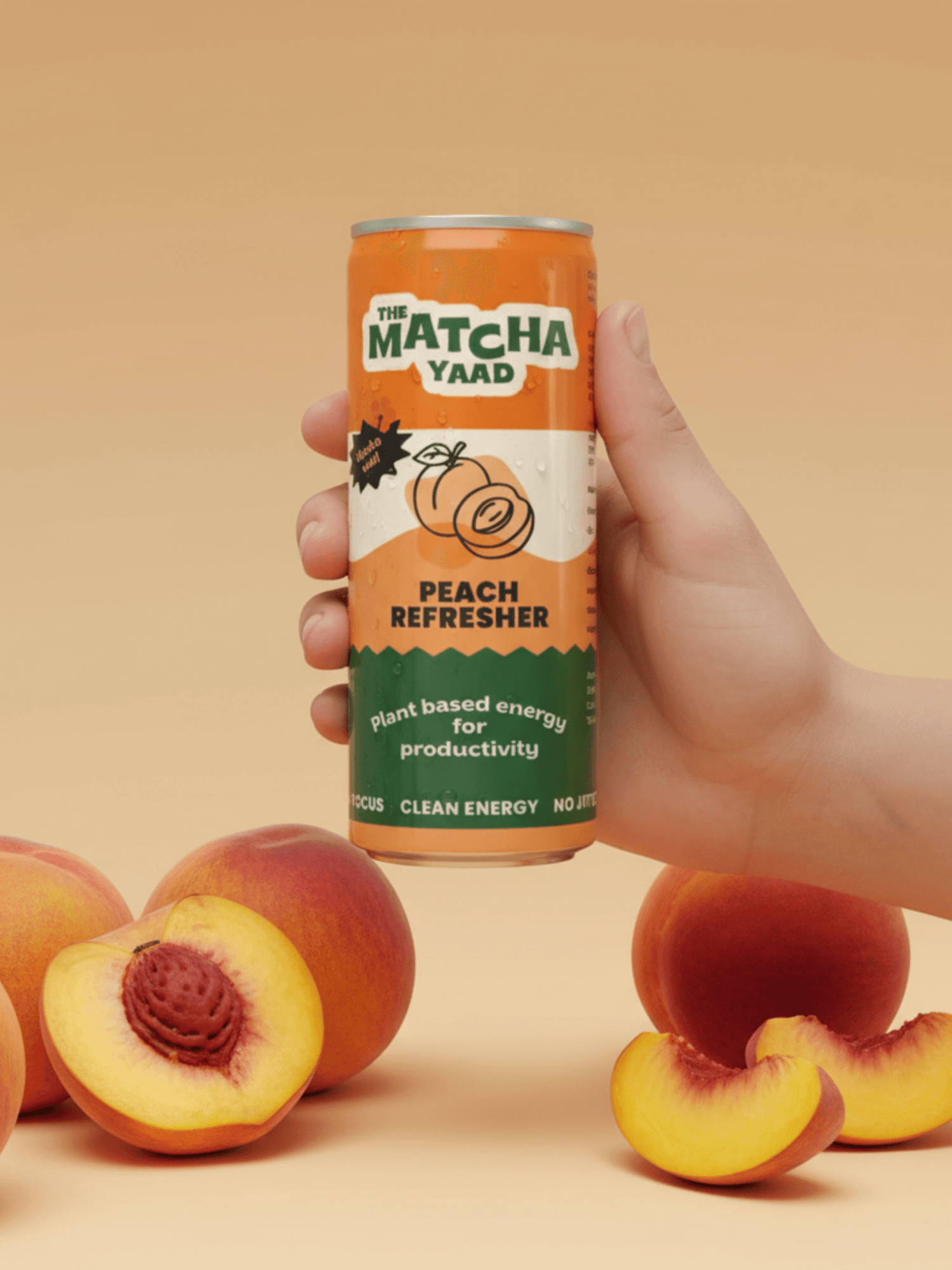 Hand holding Peach Refresher matcha energy drink can with fresh peaches around, showcasing a natural, uplifting beverage for clean energy.