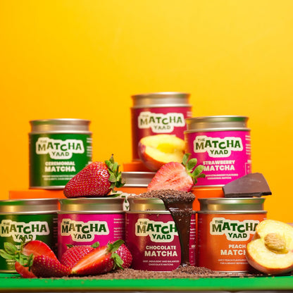 Assorted tins of Matcha Yada with fruits on a yellow background
